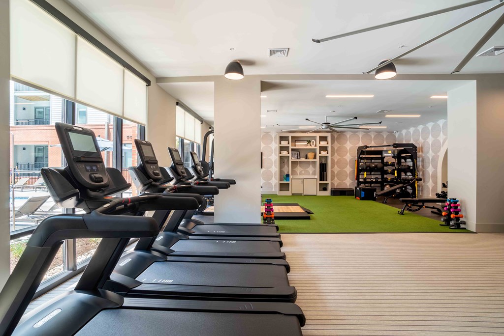 a gym with cardio equipment and a green rug at the Riverwalk, Wilmington