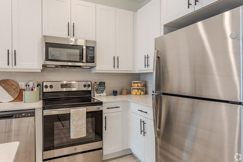 a kitchen with stainless steel appliances and white cabinets at Metropolitan at the Riverwalk, North Carolina