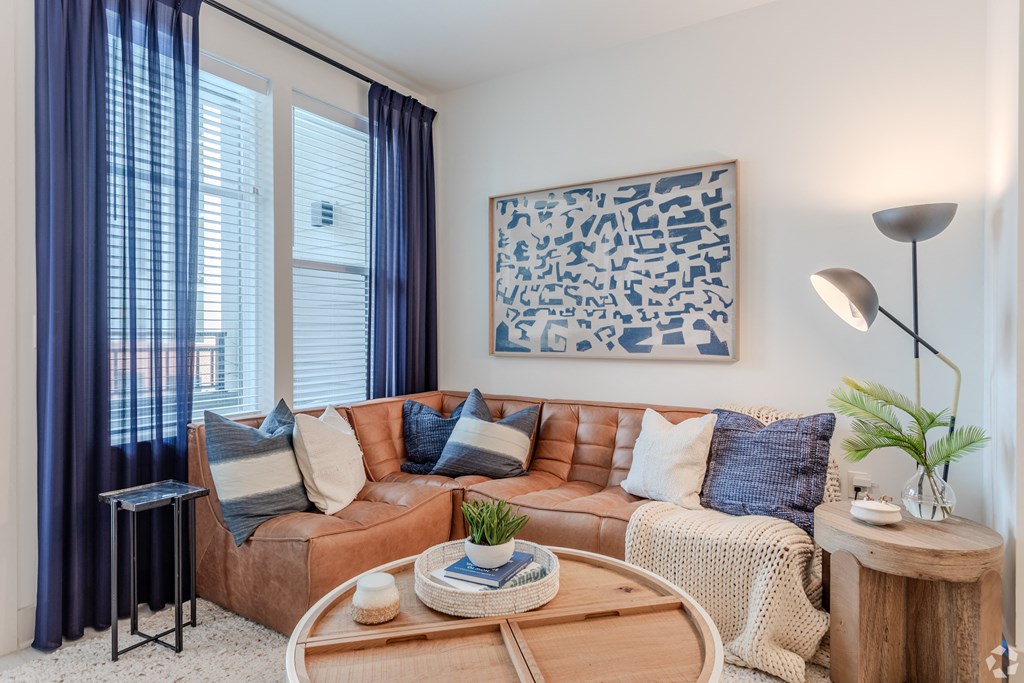 a living room with a brown couch and a coffee tableat Metropolitan at the Riverwalk, North Carolina