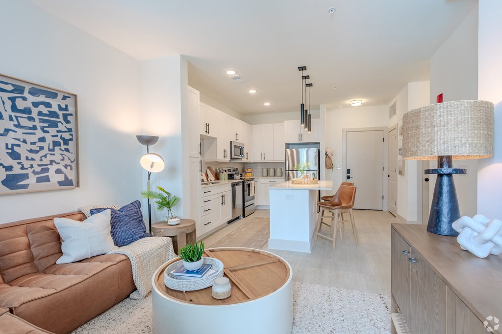 a living room and kitchen with a couch and a table  at Metropolitan at the Riverwalk, Wilmington, NC, 28401
