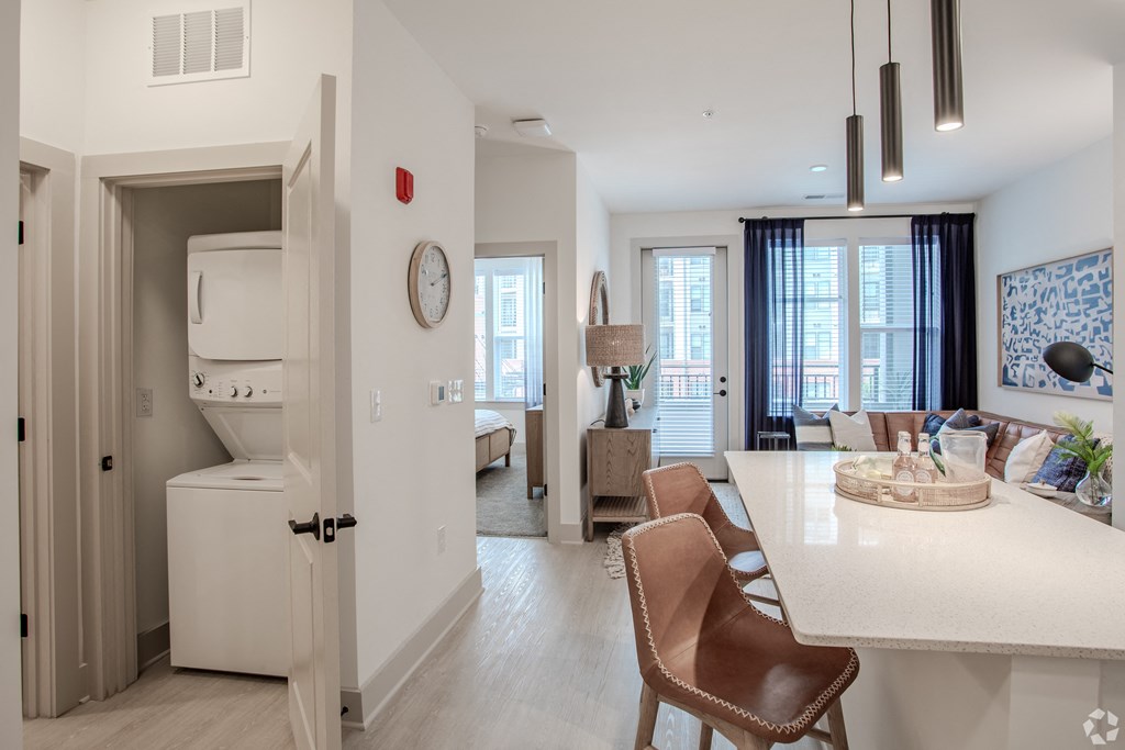 an open kitchen and living room with a dining room table and chairs  at Metropolitan at the Riverwalk, Wilmington, NC