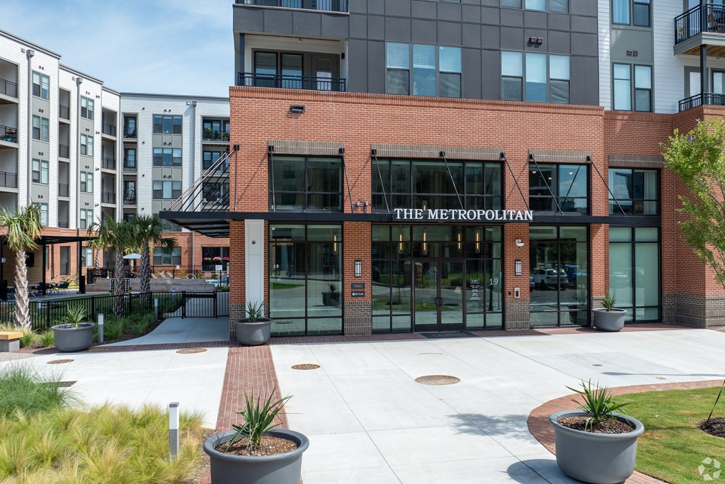 a brick building with glass doors and a sign that reads the metropolitan at Metropolitan at the Riverwalk, Wilmington, NC