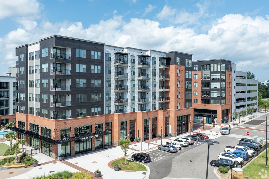 an exterior view of an apartment building with cars parked in a parking lotat the Riverwalk, Wilmington, NC 28401