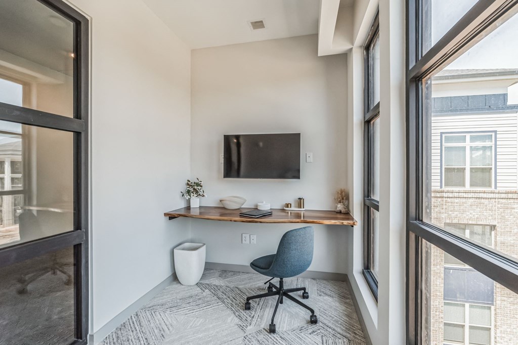 a home office with a desk and a tv in a window at Preston Ridge, Cary