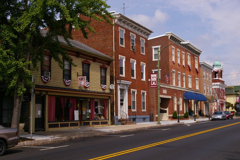 a city street with three brick buildings on the corner of a street