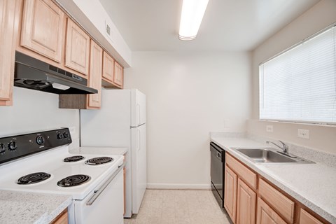 a kitchen with white appliances and wooden cabinets and a sink