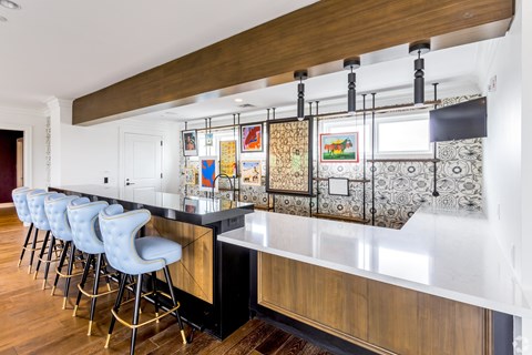 a kitchen with a long counter top and bar stools