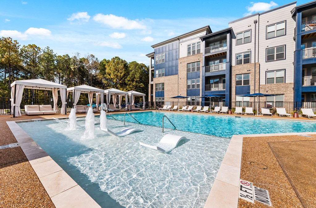 A pool with a fountain and cabanas at Preston Ridge.