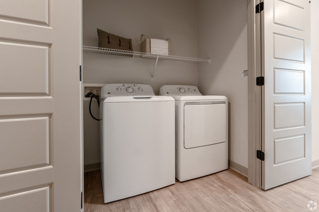 an empty laundry room with two washes and a dryer in it at Preston Ridge, Cary, NC