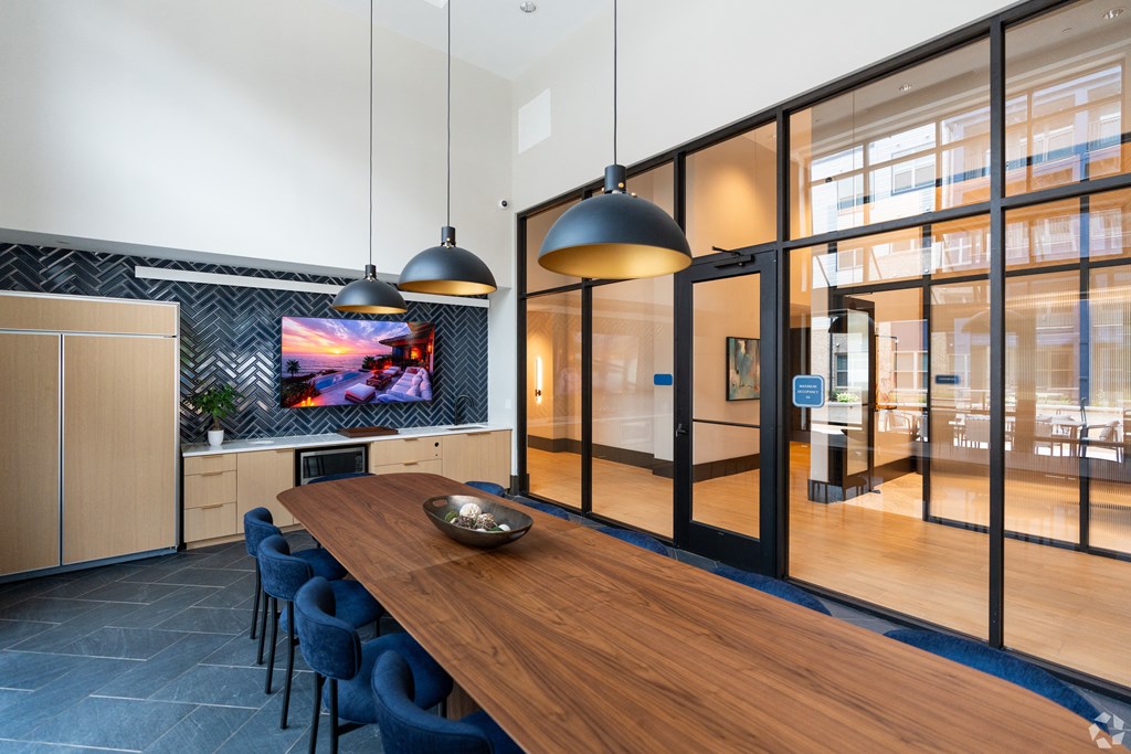 a dining room with a wooden table and blue chairs at Preston Ridge, Cary, NC