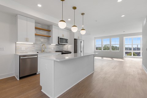 a large white kitchen with an island and stainless steel appliances at Rialto, Washington, DC