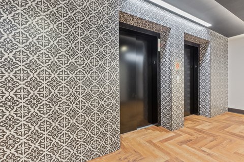 a corridor with two doors and a wooden floor and a patterned wall paper at Rialto, Washington