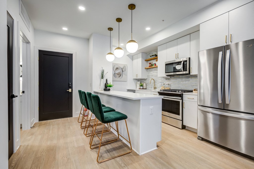 a kitchen with stainless steel appliances and an island with green chairs at Rialto, Washington, 20002