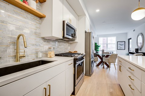 a kitchen with white cabinets and stainless steel appliances and a sink at Rialto, District of Columbia
