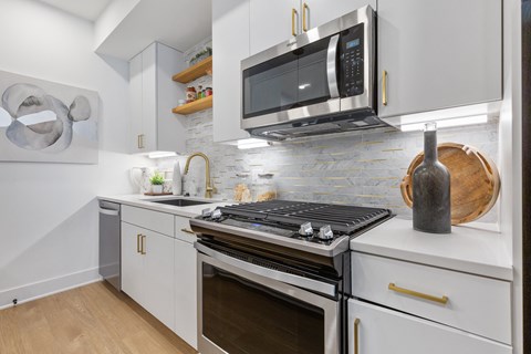 a kitchen with white cabinets and a stove and a microwave at Rialto, Washington, DC 20002