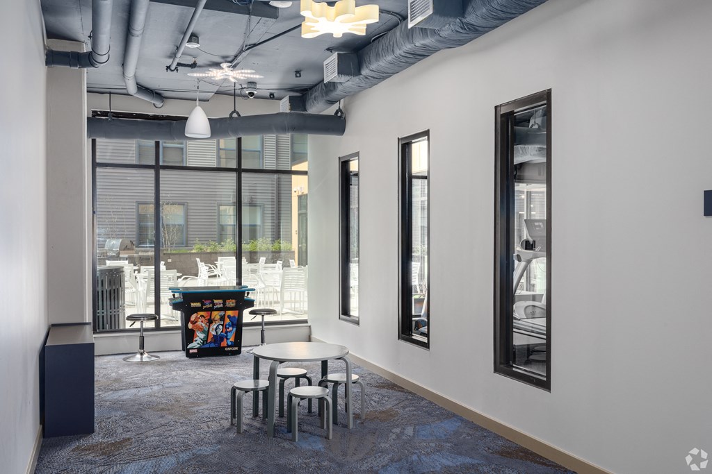 a room with a table and chairs and a large window