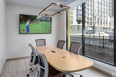 a conference room with a tv and a table with chairs