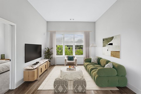 A modern living room with a green sofa and a television.