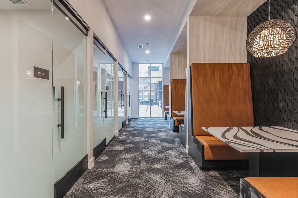 a long hallway with tables and chairs and glass doors at South and Hollis, Charlotte, NC