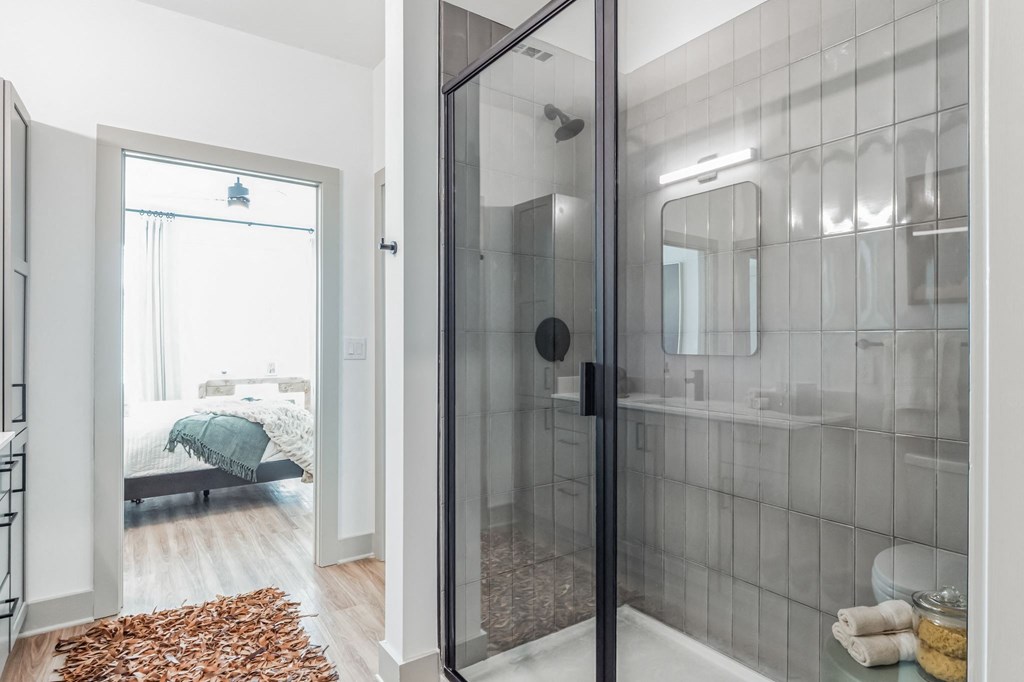 a bathroom with a glass shower and a bedroom with a bed at South and Hollis, Charlotte, NC, 28209