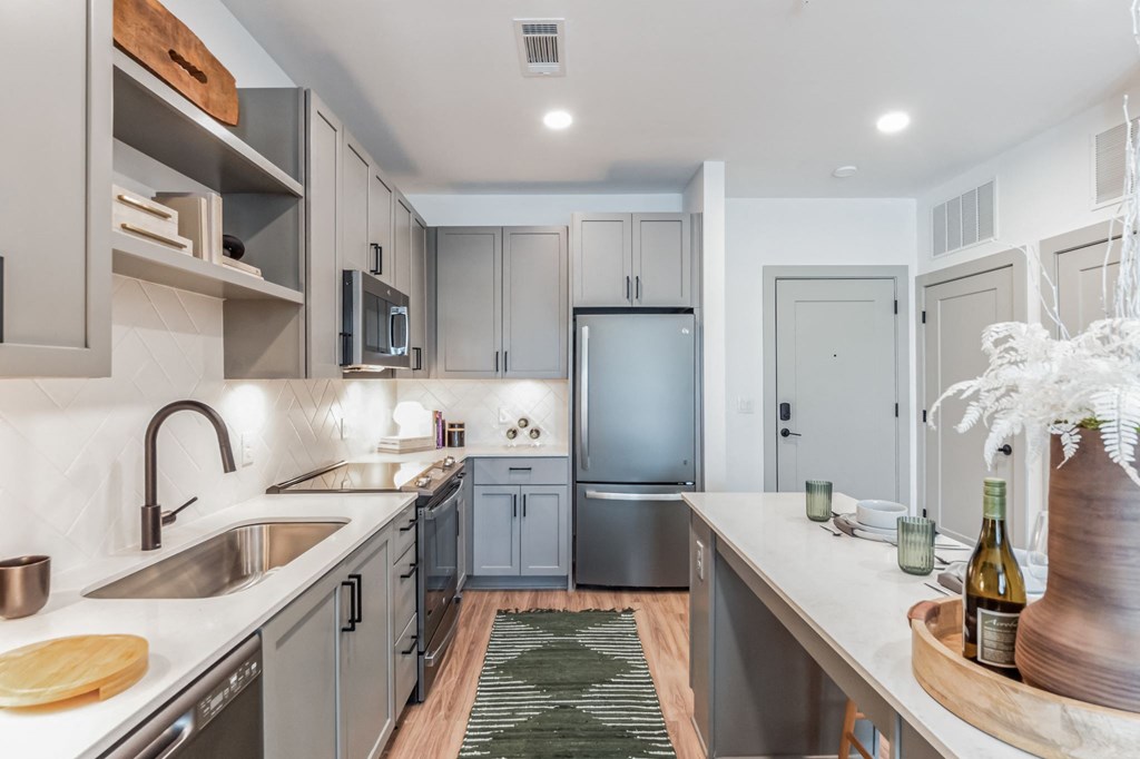 a renovated kitchen with stainless steel appliances and white countertops at South and Hollis, Charlotte, NC