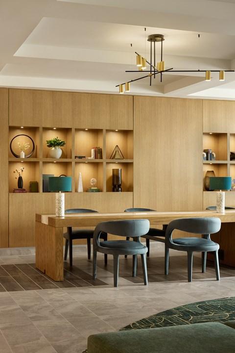 A modern dining room with a wooden table and grey chairs.