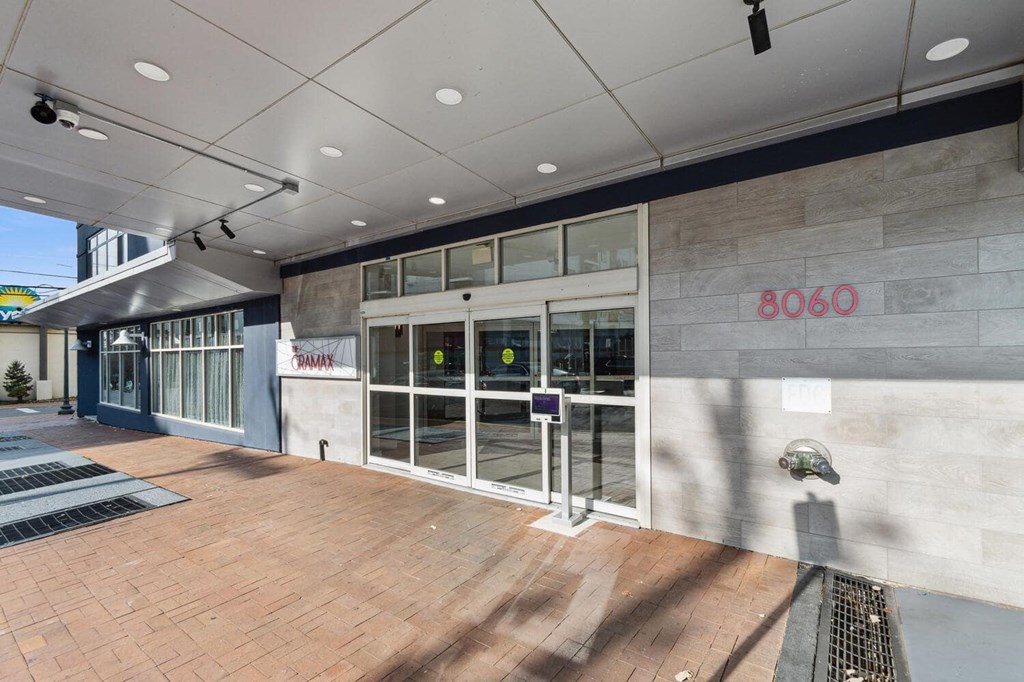 the lobby of a building with glass doors and a wood floor at The Gramax, Silver Spring