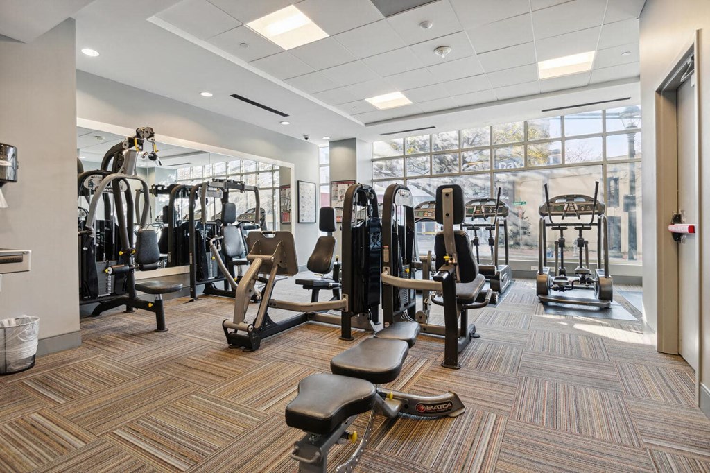 a gym with weights and cardio equipment in a building at The Gramax, Silver Spring, Maryland