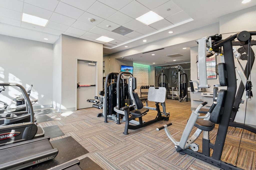 a gym with weights and cardio equipment in a building at The Gramax, Silver Spring, 20910