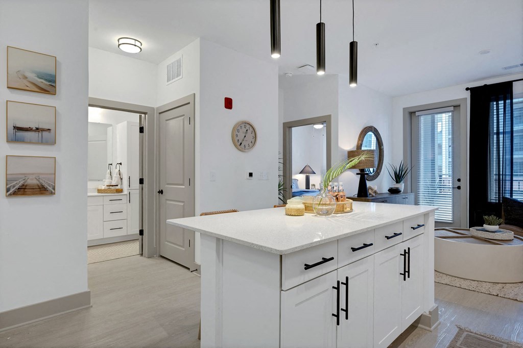 a white kitchen with an island and a door to a bathroom at Metropolitan at the Riverwalk, Wilmington, 28401