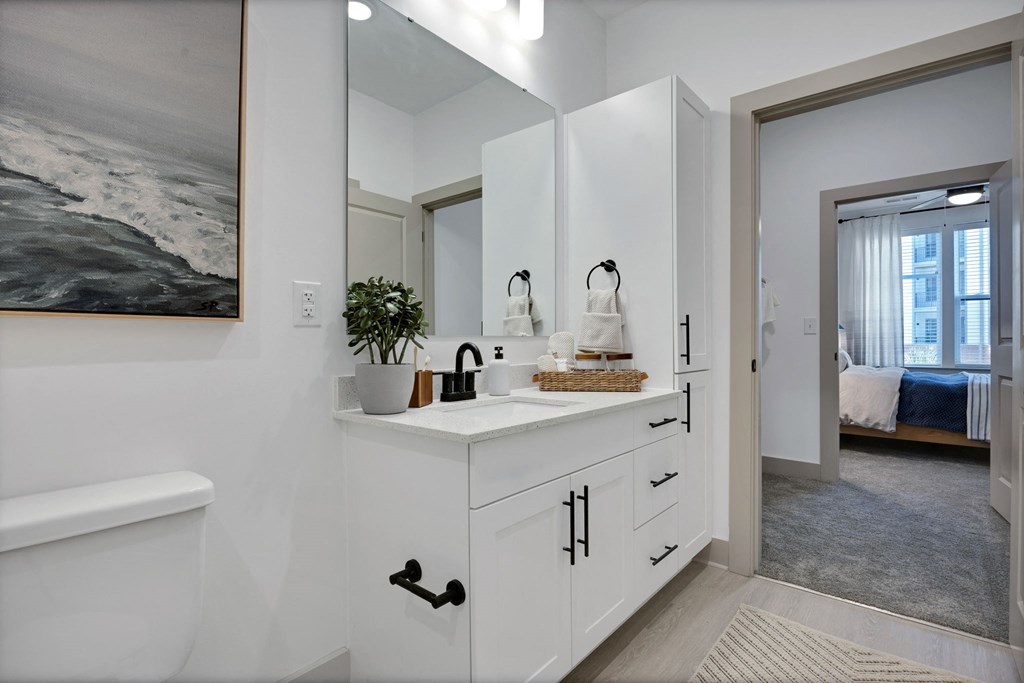 a white bathroom with a sink and a mirror at the Riverwalk, Wilmington, NC 28401