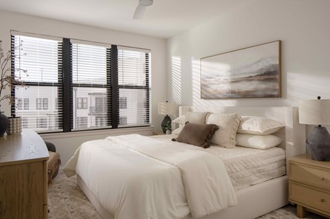 A bedroom with a large bed and a painting on the wall.