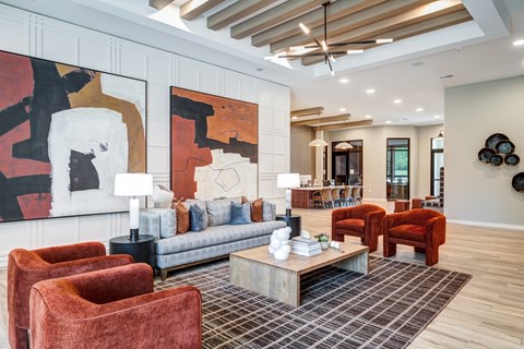 A living room with a grey couch, a coffee table and a painting on the wall.