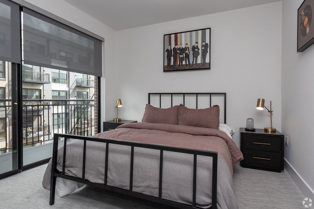 a bedroom with a bed and a large window