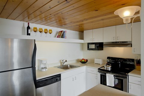 a kitchen with white cabinets and a stainless steel refrigerator