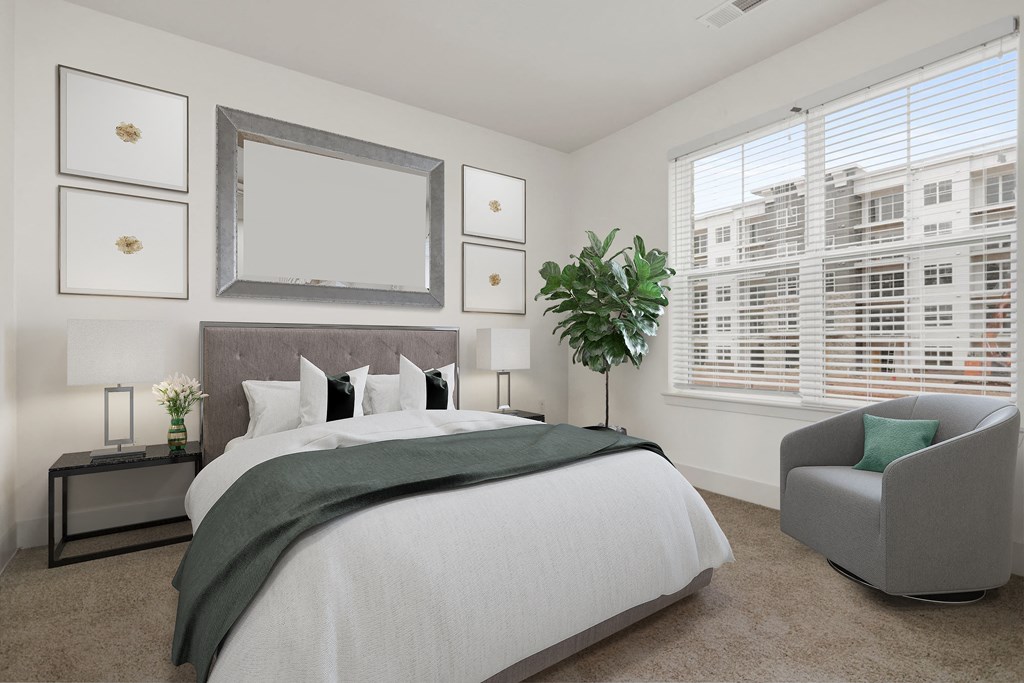 a bedroom with a large bed and two windows