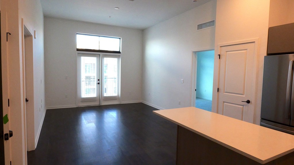 an empty living room with white walls and a window