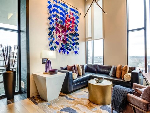 a living room with leather couches and a large artwork on the wall