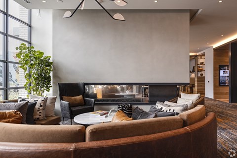 A living room with a brown couch and a fireplace.