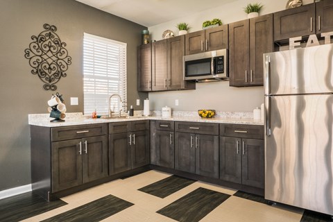 A kitchen with brown cabinets and a white fridge.