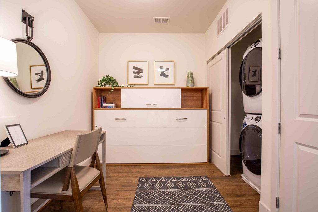 a laundry room with a table and chairs and a washing machine at Woodmore Grand, Bowie