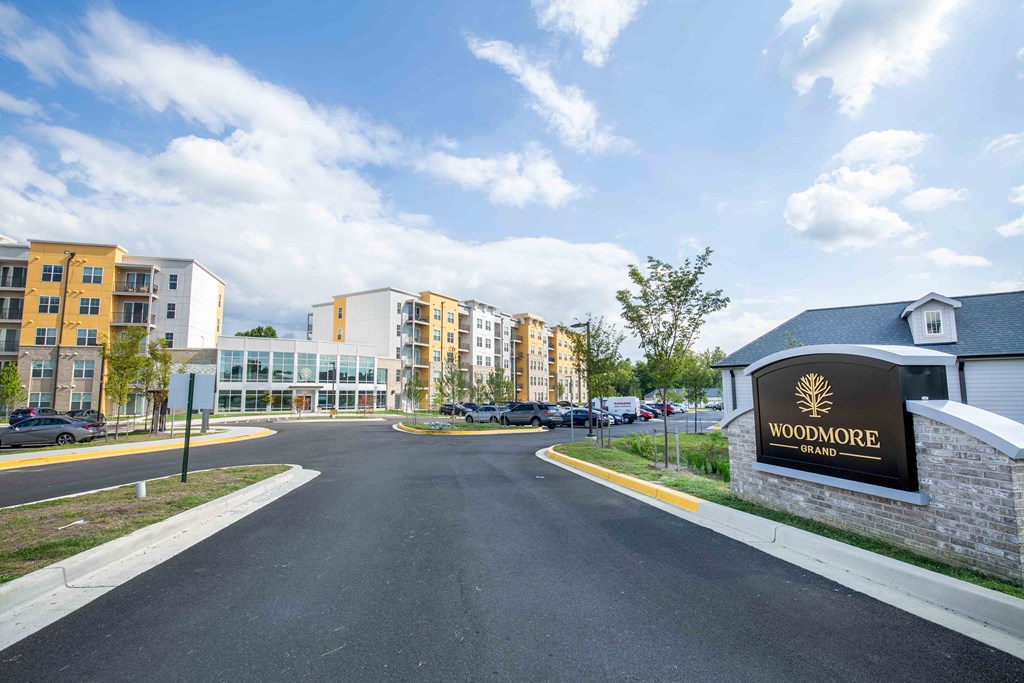 a road leading to a building with a sign at Woodmore Grand, Bowie, 20721