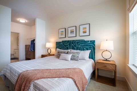 a bedroom with a bed and pictures on the wall at Woodmore Grand, Bowie