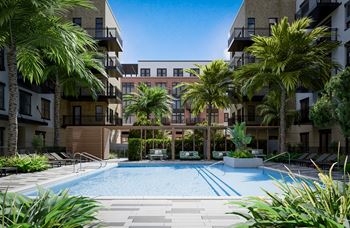 a large swimming pool with palm trees in front of an apartment building