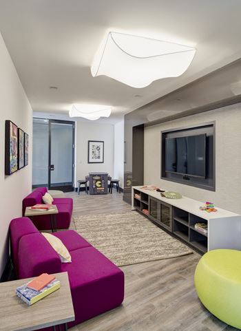 a living room with a purple couch and a television at Fort Totten Square, Washington DC, 20011