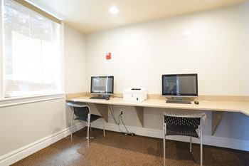A room with a desk and two chairs.