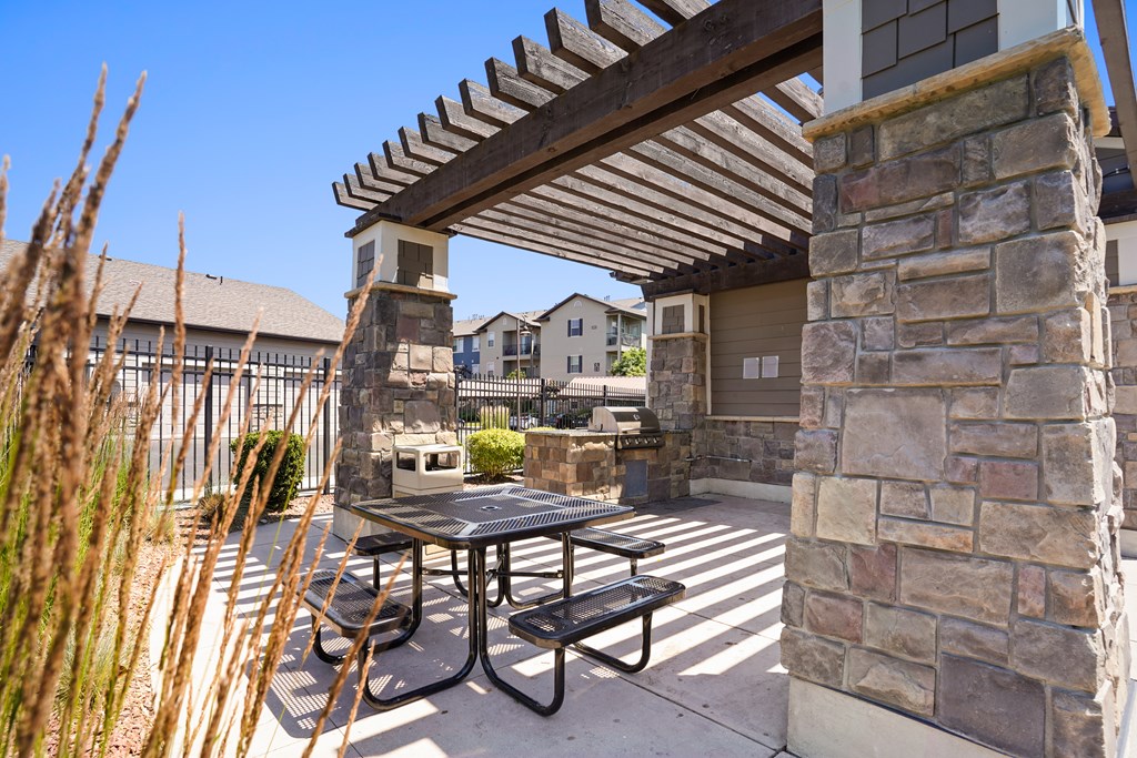 A patio with a table and chairs under a pergola.at Florentine Villas, Midvale, UT 84047