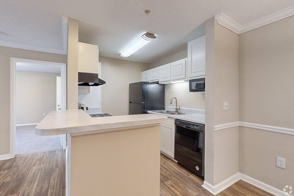 a kitchen with a large counter top and a black refrigerator at Alexander Ridge Apartments, Canton , GA