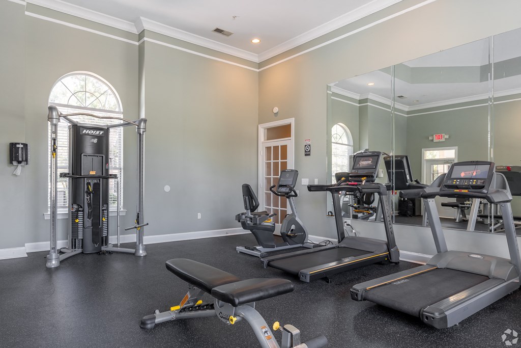 a gym with treadmills and other exercise equipment in the corner of a room at Alexander Ridge Apartments, Canton
