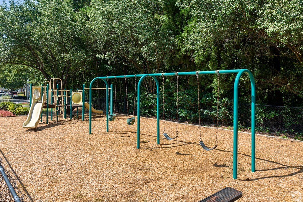 a playground with a swing set and other playground equipment at Alexander Ridge Apartments, Canton